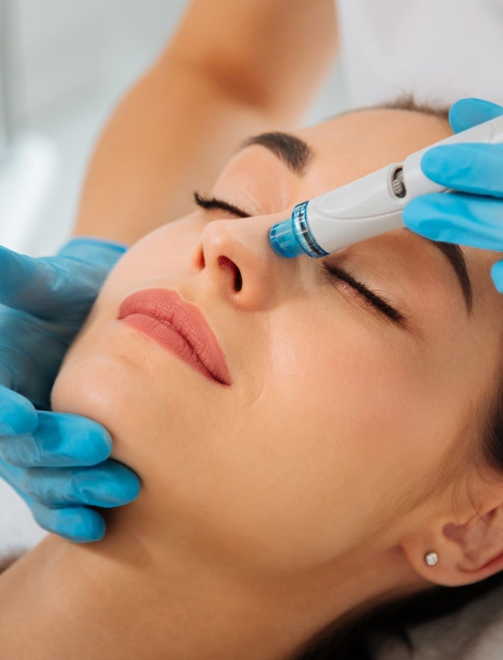 Une femme se fait nettoyer la peau du nez par un professionnel de l’Hydrafacial au centre esthetique et laser tremoille a paris 8